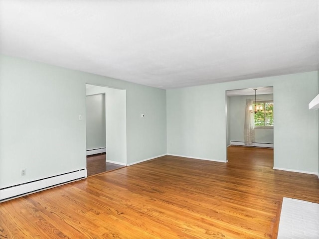 119 Abington Dr, Mt Lebanon, PA 15216 - empty room with wood finished floors, baseboard heating, a baseboard heating unit, and a chandelier
