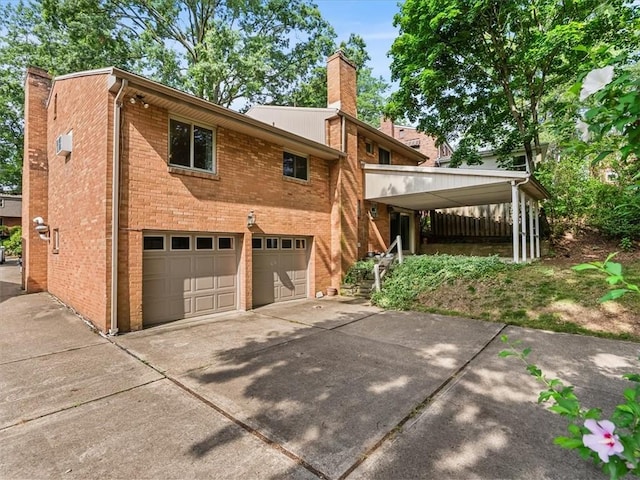 119 Abington Dr, Mt Lebanon, PA 15216 - view of home's exterior with a chimney, driveway, brick siding, and an attached garage