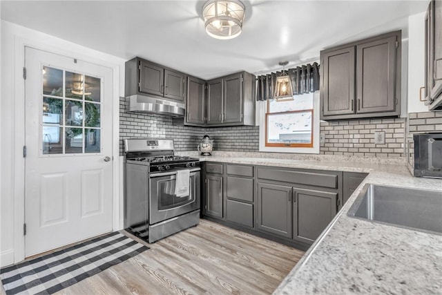 203 Stoney Hollow Rd, Winfield Twp, PA 16023 - kitchen with gas range, under cabinet range hood, light wood finished floors, and tasteful backsplash