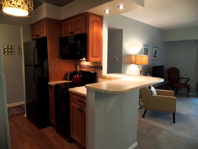 2160 Greentree Rd Unit 701W, Pittsburgh, PA 15220 - kitchen featuring black appliances, decorative backsplash, light countertops, a peninsula, and a breakfast bar