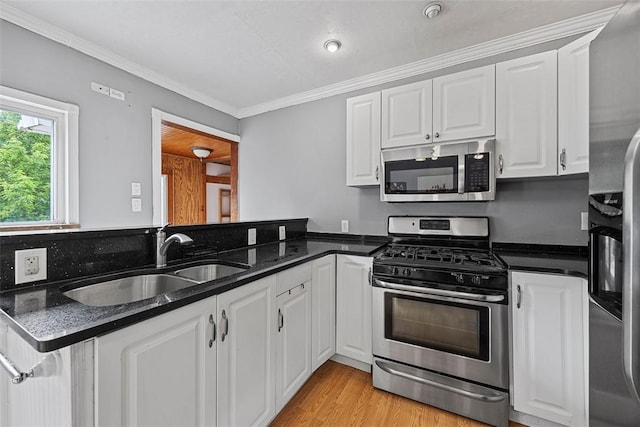 107 Ambridge Ave, Leet Twp, PA 15003 - kitchen featuring appliances with stainless steel finishes, white cabinetry, crown molding, light wood-type flooring, and dark stone counters
