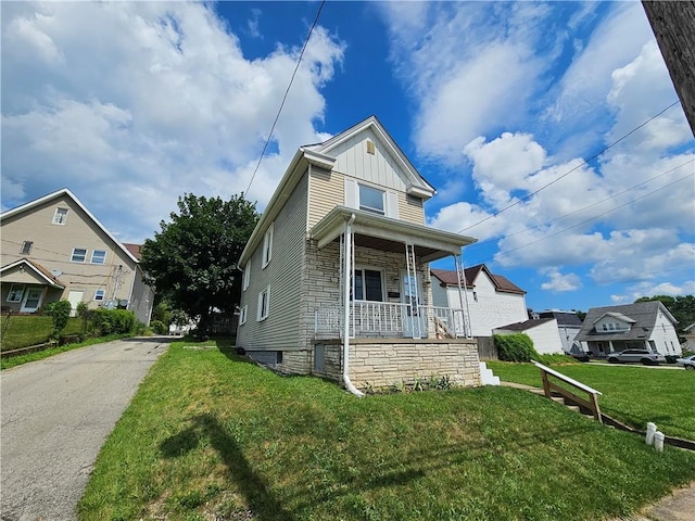596 Beech St, City Of Washington, PA 15301 - view of front of home featuring a porch, board and batten siding, a front yard, stone siding, and driveway