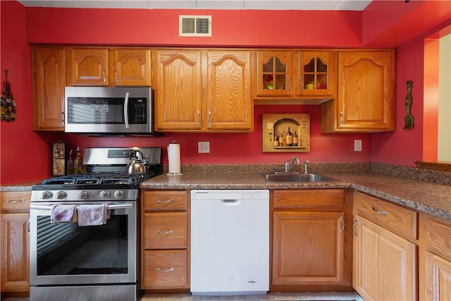 2034 Swallow Hill Rd Unit 419, Pittsburgh, PA 15220 - kitchen featuring appliances with stainless steel finishes, brown cabinets, and glass insert cabinets