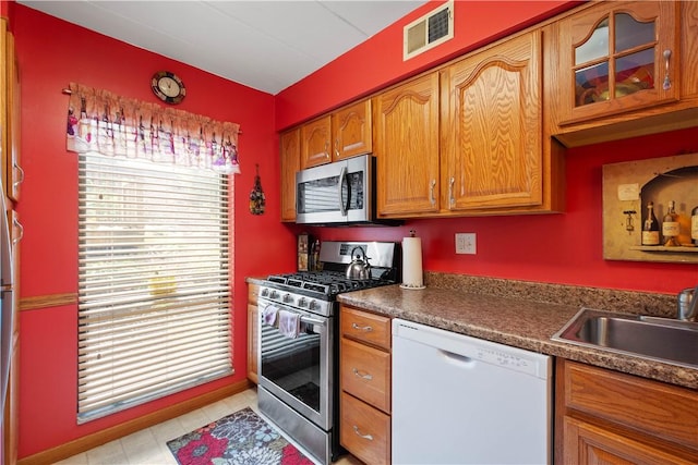 2034 Swallow Hill Rd Unit 419, Pittsburgh, PA 15220 - kitchen featuring stainless steel appliances, dark countertops, brown cabinets, and glass insert cabinets