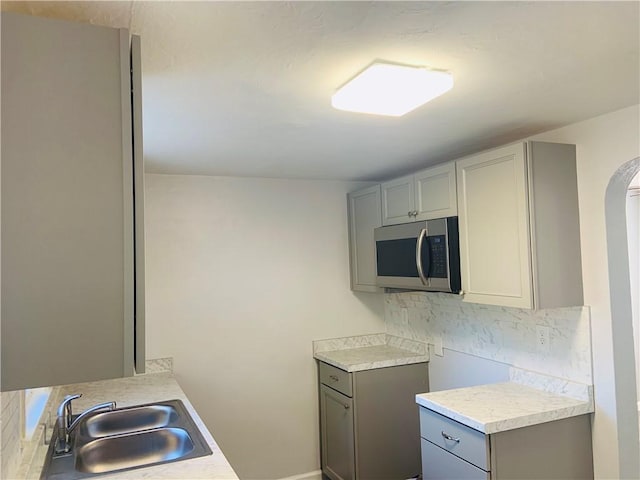 120 Graham Ave N, Versailles, PA 15137 - kitchen with stainless steel microwave, gray cabinets, light countertops, and decorative backsplash