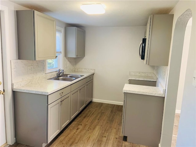 120 Graham Ave N, Versailles, PA 15137 - kitchen with gray cabinetry, stainless steel microwave, light countertops, and wood finished floors