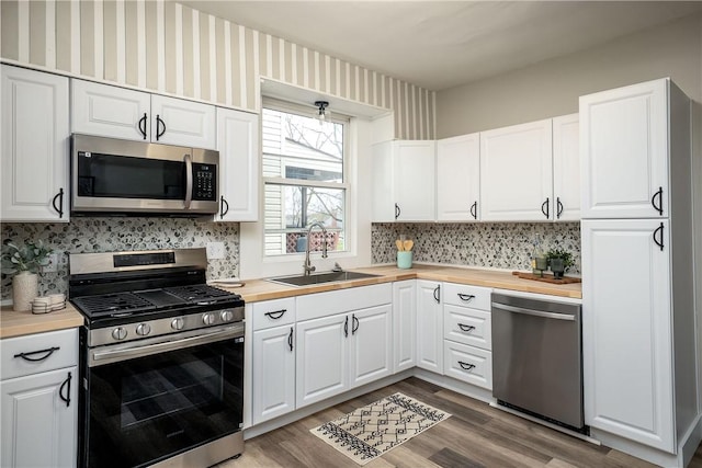 1122 Wade St, Aliquippa, PA 15001 - kitchen with stainless steel appliances, butcher block counters, decorative backsplash, and white cabinetry