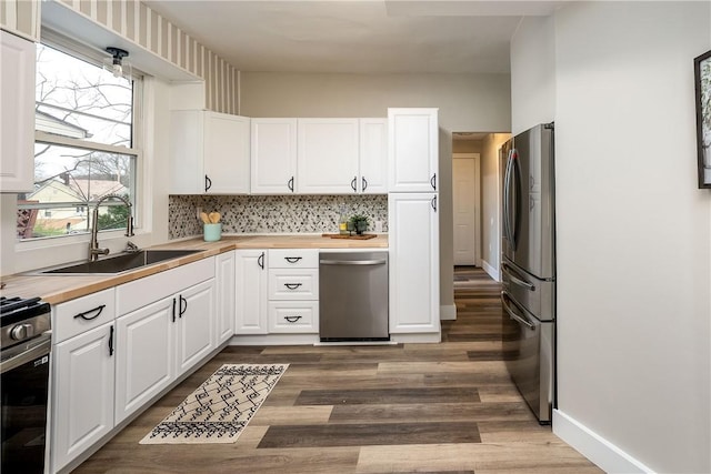 1122 Wade St, Aliquippa, PA 15001 - kitchen featuring appliances with stainless steel finishes, wooden counters, wood finished floors, and white cabinets