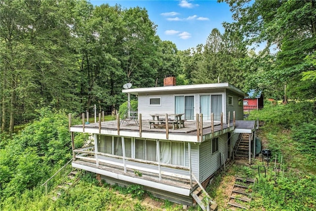 3067 N 3rd St, Jamestown, PA 16134 - rear view of house featuring stairs, a chimney, a wooden deck, and a wooded view