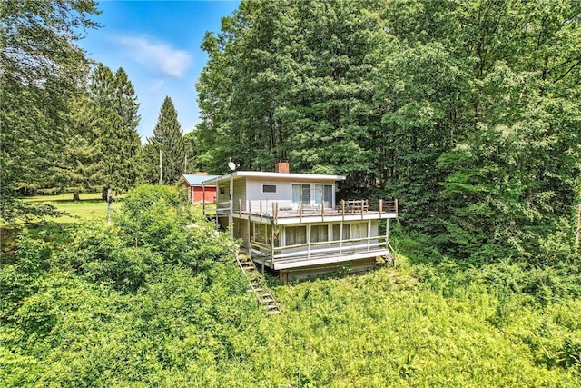 3067 N 3rd St, Jamestown, PA 16134 - rear view of house featuring a wooded view, a deck, and a chimney