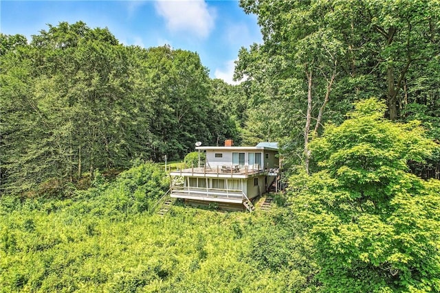 3067 N 3rd St, Jamestown, PA 16134 - rear view of property featuring stairway, a forest view, a wooden deck, and a chimney