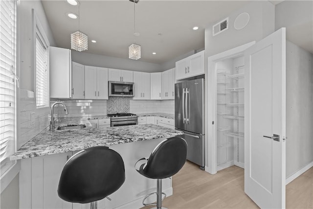 1825 Arcena St Unit 3, Downtown Pgh, PA 15219 - kitchen with stainless steel appliances, light stone countertops, light wood-style flooring, a peninsula, and recessed lighting