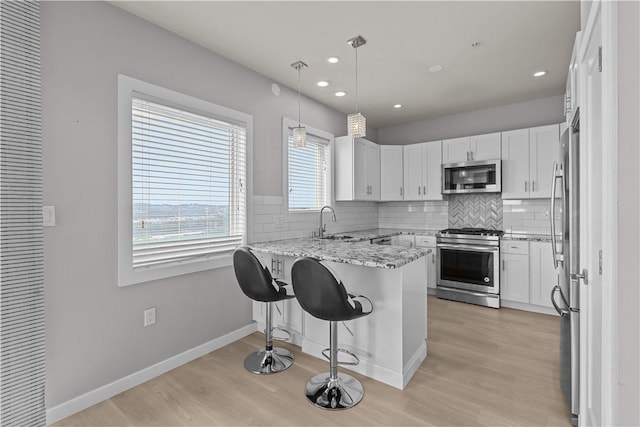 1825 Arcena St Unit 3, Downtown Pgh, PA 15219 - kitchen featuring stainless steel appliances, a peninsula, light wood-type flooring, light stone countertops, and backsplash
