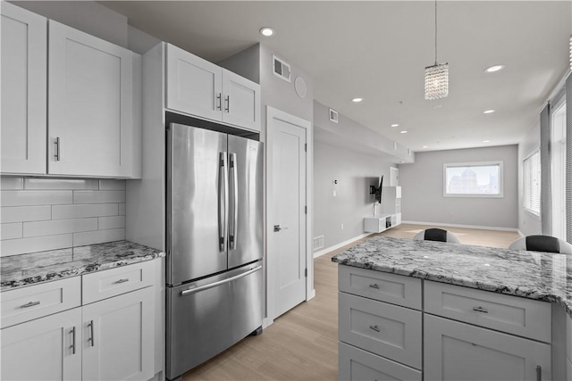 1825 Arcena St Unit 3, Downtown Pgh, PA 15219 - kitchen with freestanding refrigerator, light wood-style flooring, decorative backsplash, recessed lighting, and light stone counters
