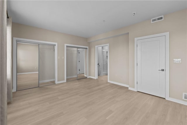 1825 Arcena St Unit 3, Downtown Pgh, PA 15219 - unfurnished bedroom with multiple closets, light wood finished floors, and ensuite bath