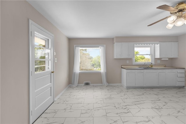 108 Dave St, Daugherty Twp, PA 15066 - kitchen featuring light marble finish floors, white cabinetry, and a ceiling fan