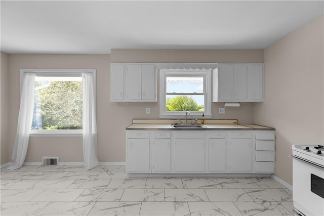 108 Dave St, Daugherty Twp, PA 15066 - kitchen with white electric range, light marble finish floors, white cabinetry, and healthy amount of natural light
