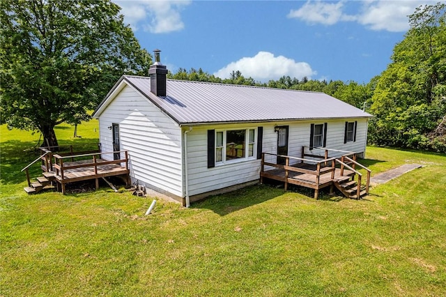 304 Wirsing Rd, Wharton Twp, PA 15440 - rear view of house featuring a wooden deck, a chimney, a metal roof, and a yard