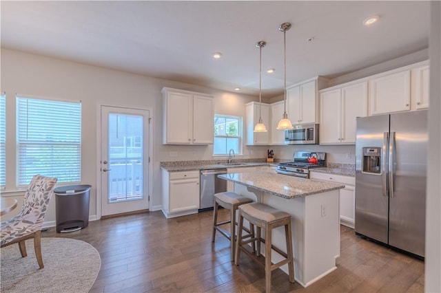812 Theda Dori St, Cranberry Twp, PA 16066 - kitchen featuring appliances with stainless steel finishes, white cabinets, a center island, dark wood-style floors, and decorative light fixtures