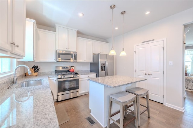 812 Theda Dori St, Cranberry Twp, PA 16066 - kitchen with stainless steel appliances, light wood-style floors, white cabinets, a center island, and recessed lighting