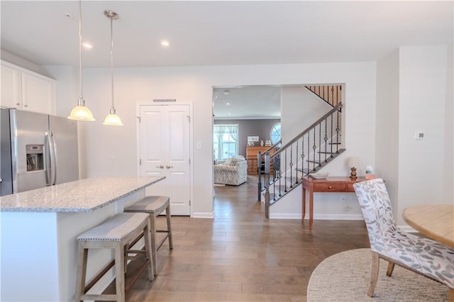 812 Theda Dori St, Cranberry Twp, PA 16066 - kitchen featuring stainless steel refrigerator with ice dispenser, wood finished floors, light stone countertops, white cabinetry, and a kitchen island