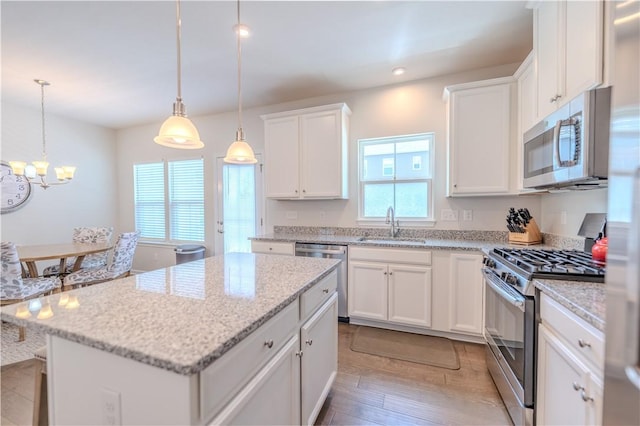 812 Theda Dori St, Cranberry Twp, PA 16066 - kitchen featuring stainless steel appliances, a kitchen island, white cabinets, light wood-style flooring, and a chandelier