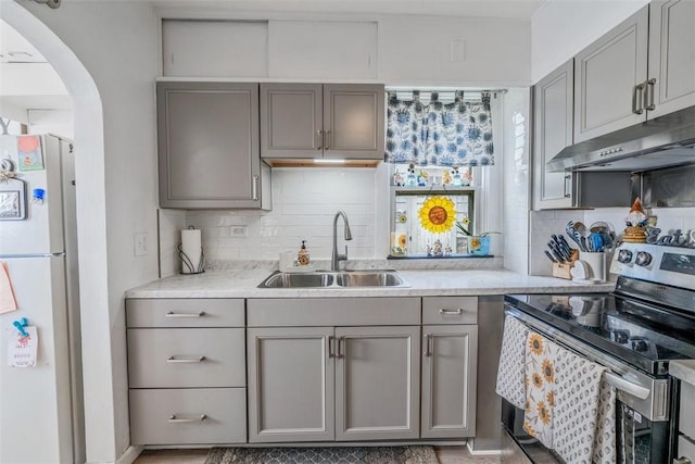 432 Kenmont Ave, Mt Lebanon, PA 15228 - kitchen featuring stainless steel electric range, gray cabinetry, freestanding refrigerator, under cabinet range hood, and arched walkways