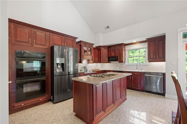 228 Highpointe Dr, Pittsburgh, PA 15220 - kitchen with black appliances, reddish brown cabinets, backsplash, light stone counters, and a center island