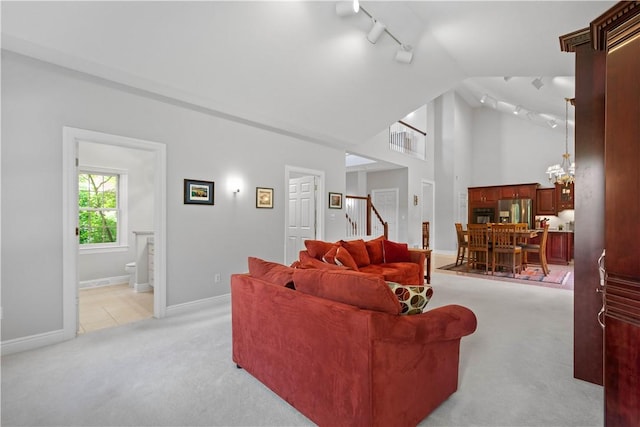 228 Highpointe Dr, Pittsburgh, PA 15220 - living room with track lighting, light colored carpet, stairway, and high vaulted ceiling