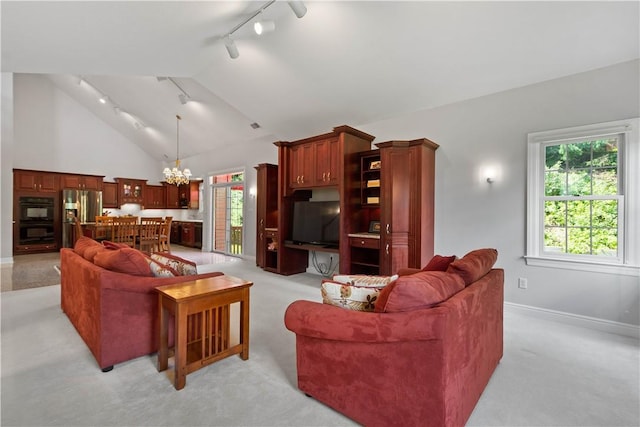 228 Highpointe Dr, Pittsburgh, PA 15220 - living room featuring rail lighting, light colored carpet, a chandelier, vaulted ceiling, and plenty of natural light