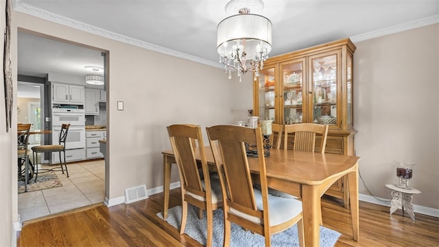 341 E Mcmurray, Peters Twp, PA 15317 - dining space featuring ornamental molding, light wood-style flooring, and a chandelier
