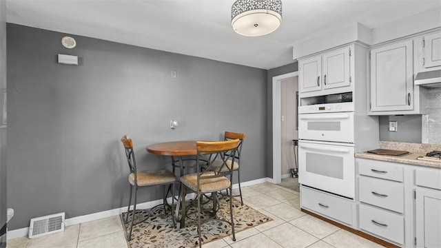 341 E Mcmurray, Peters Twp, PA 15317 - kitchen with double oven, light countertops, light tile patterned floors, and under cabinet range hood