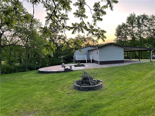 170 Laidleys Run Rd, West Finley, PA 15376 - yard at dusk with a wooden deck, a carport, an outdoor fire pit, and a yard