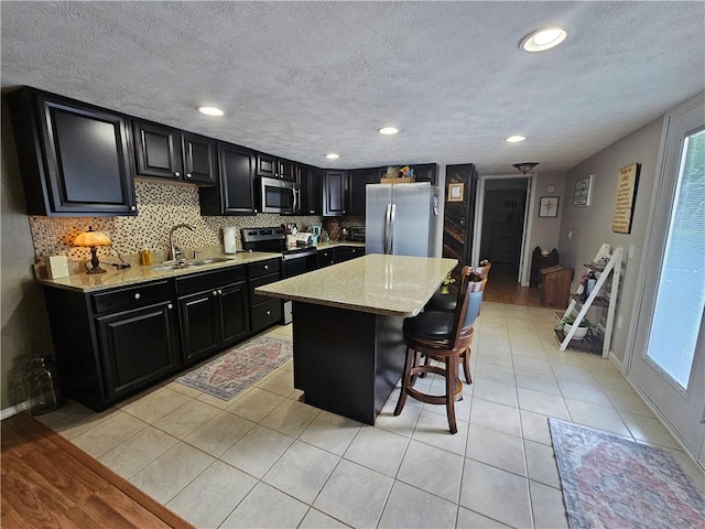170 Laidleys Run Rd, West Finley, PA 15376 - kitchen with stainless steel appliances, dark cabinetry, a breakfast bar, a kitchen island, and recessed lighting