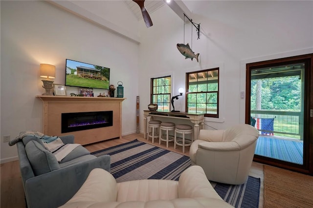 214 Youngs Ln, Sugarcreek, PA 16323 - living room with beam ceiling, a glass covered fireplace, wood finished floors, high vaulted ceiling, and a ceiling fan
