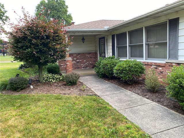 39 Hogue Rd, West Middlesex Boro, PA 16159 - property entrance with brick siding, a lawn, roof with shingles, and a porch
