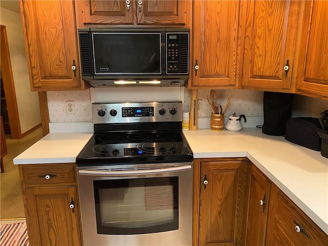 39 Hogue Rd, West Middlesex Boro, PA 16159 - kitchen featuring stainless steel electric stove, black microwave, and brown cabinetry