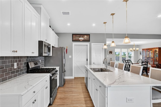 106 High Pointe Dr, Chartiers, PA 15301 - kitchen featuring stainless steel appliances, an island with sink, white cabinetry, tasteful backsplash, and light wood-style floors