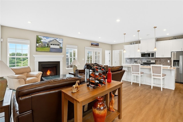 106 High Pointe Dr, Chartiers, PA 15301 - living room with healthy amount of natural light, light wood-type flooring, a warm lit fireplace, and recessed lighting