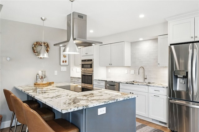 1206 Carla Dr, Blawnox, PA 15238 - kitchen with appliances with stainless steel finishes, island range hood, a breakfast bar area, a peninsula, and white cabinetry