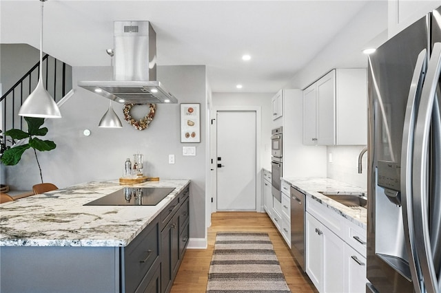 1206 Carla Dr, Blawnox, PA 15238 - kitchen with stainless steel appliances, island exhaust hood, light wood-style flooring, white cabinets, and light stone counters