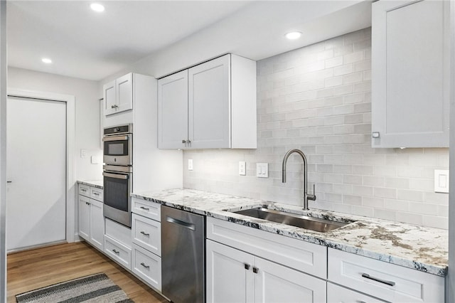 1206 Carla Dr, Blawnox, PA 15238 - kitchen with stainless steel appliances, light wood-style flooring, decorative backsplash, recessed lighting, and light stone counters