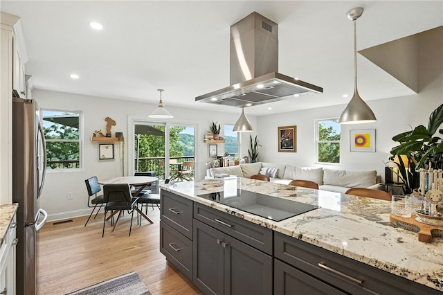 1206 Carla Dr, Blawnox, PA 15238 - kitchen featuring island exhaust hood, black electric stovetop, freestanding refrigerator, light wood-style floors, and light stone countertops