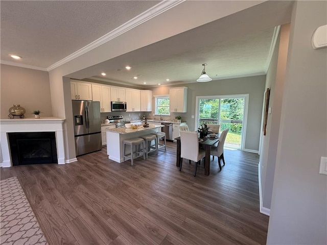 173 Lockheed Dr, Moon/Crescent Twp, PA 15108 - kitchen featuring stainless steel appliances, crown molding, white cabinets, a kitchen breakfast bar, and dark wood-style floors
