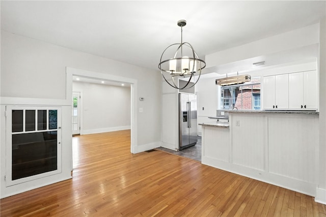 5248 Beelermont Pl, Squirrel Hill, PA 15217 - kitchen with high end refrigerator, a chandelier, light wood-style flooring, white cabinets, and a peninsula