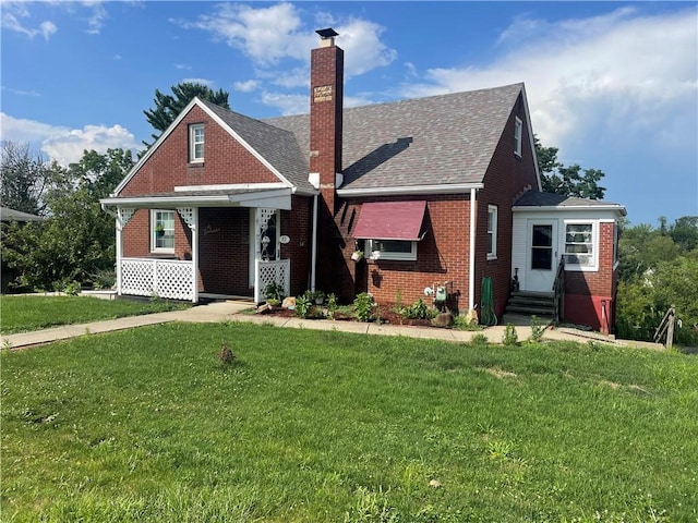 33 Orchard Ln, Carroll Twp, PA 15063 - view of front facade featuring brick siding, a chimney, entry steps, a front lawn, and covered porch