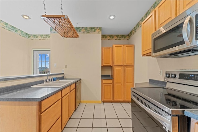 213 Pennsylvania Ave, Emsworth, PA 15202 - kitchen featuring appliances with stainless steel finishes, a peninsula, light tile patterned floors, dark countertops, and recessed lighting