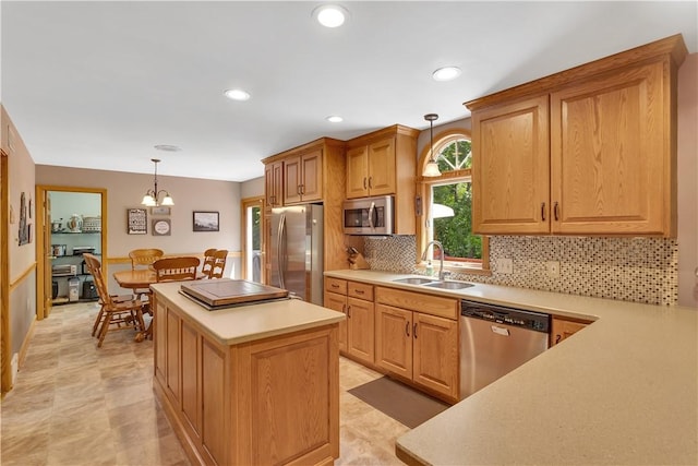 115 Barrett Dr, Brighton Twp, PA 15009 - kitchen featuring appliances with stainless steel finishes, a kitchen island, light countertops, tasteful backsplash, and a chandelier