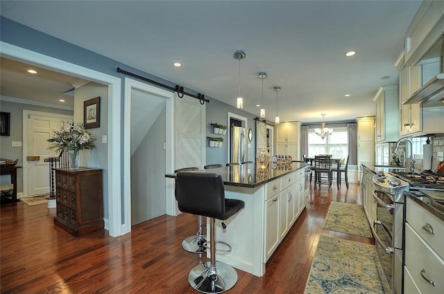 79 W Manilla Ave, Green Tree, PA 15220 - kitchen with appliances with stainless steel finishes, dark countertops, a kitchen island, dark wood-style flooring, and a barn door