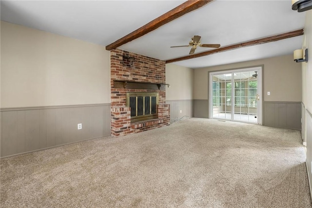 1308 Heather Heights Dr, Mccandless, PA 15101 - unfurnished living room featuring a wainscoted wall, beamed ceiling, carpet floors, ceiling fan, and a brick fireplace